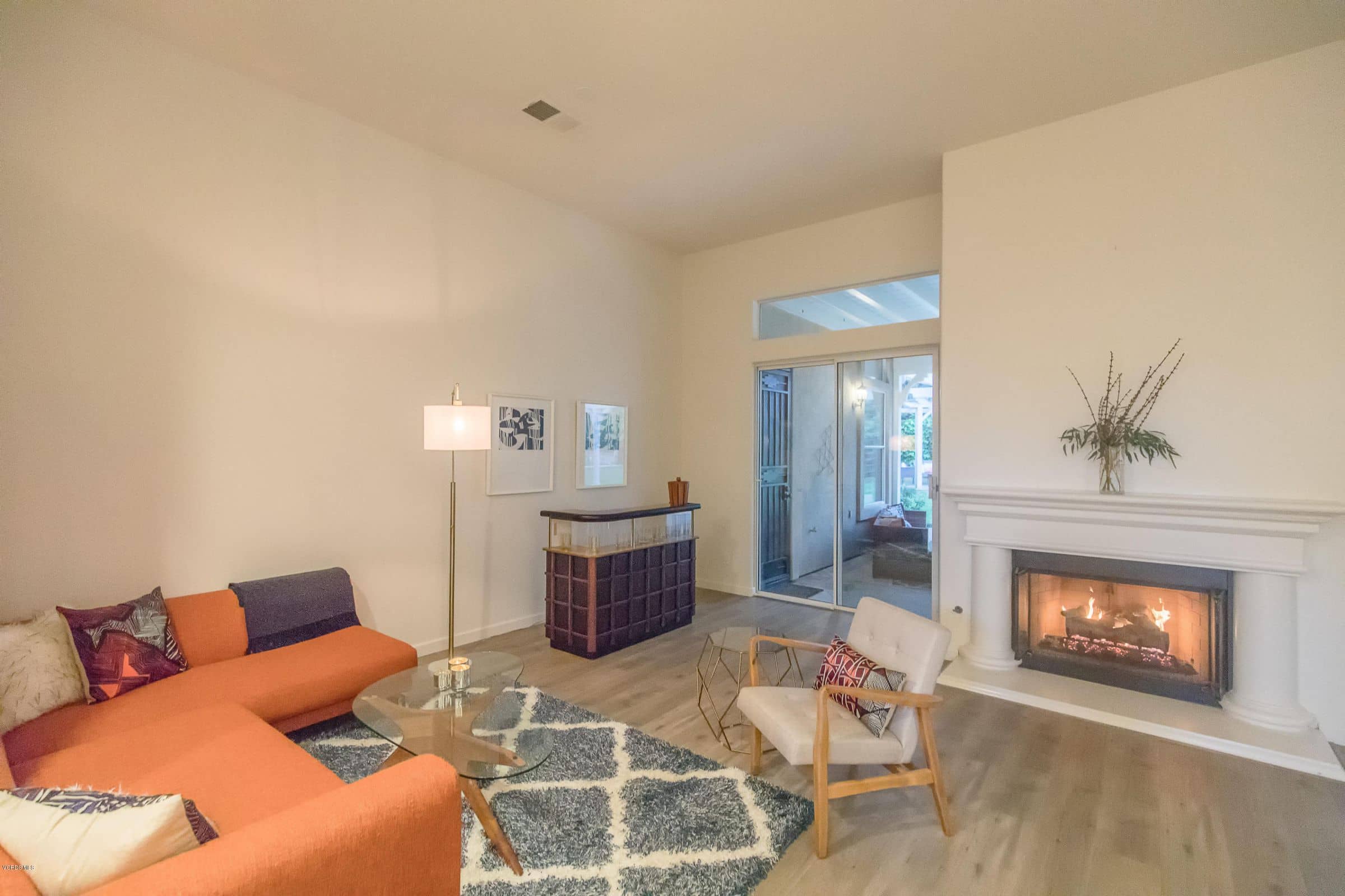 A staged living room with an orange sofa and a fireplace, from one of Connie's listings