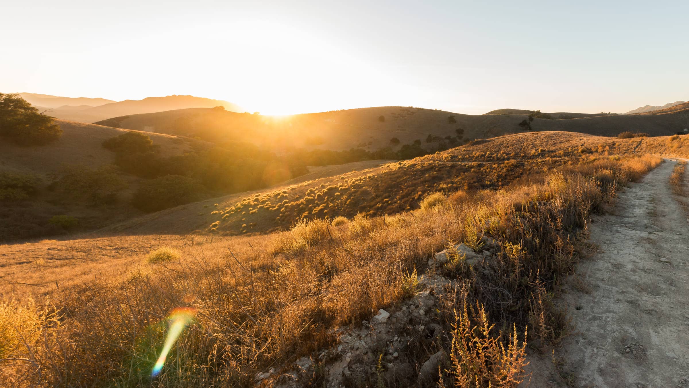Golden hills and a dirt trail at sunset in Cheeseboro Canyon, Santa Monica Mountains
